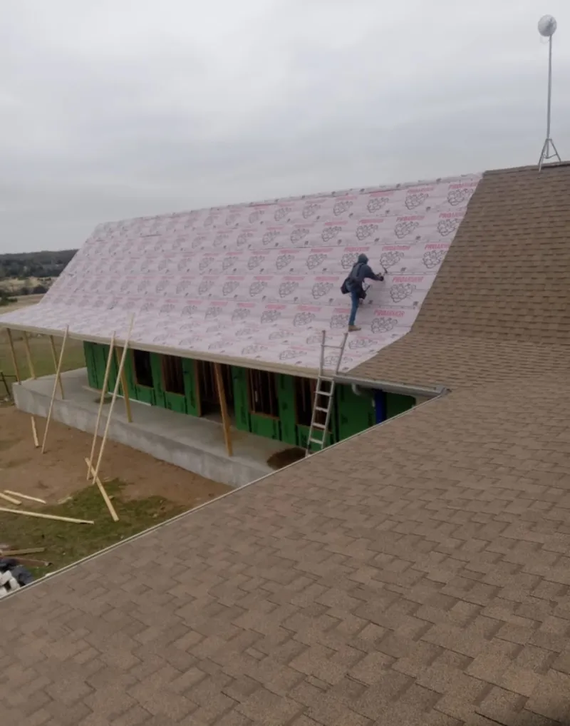 Worker preparing underlayment for a metal roof installation in Myrtle Beach